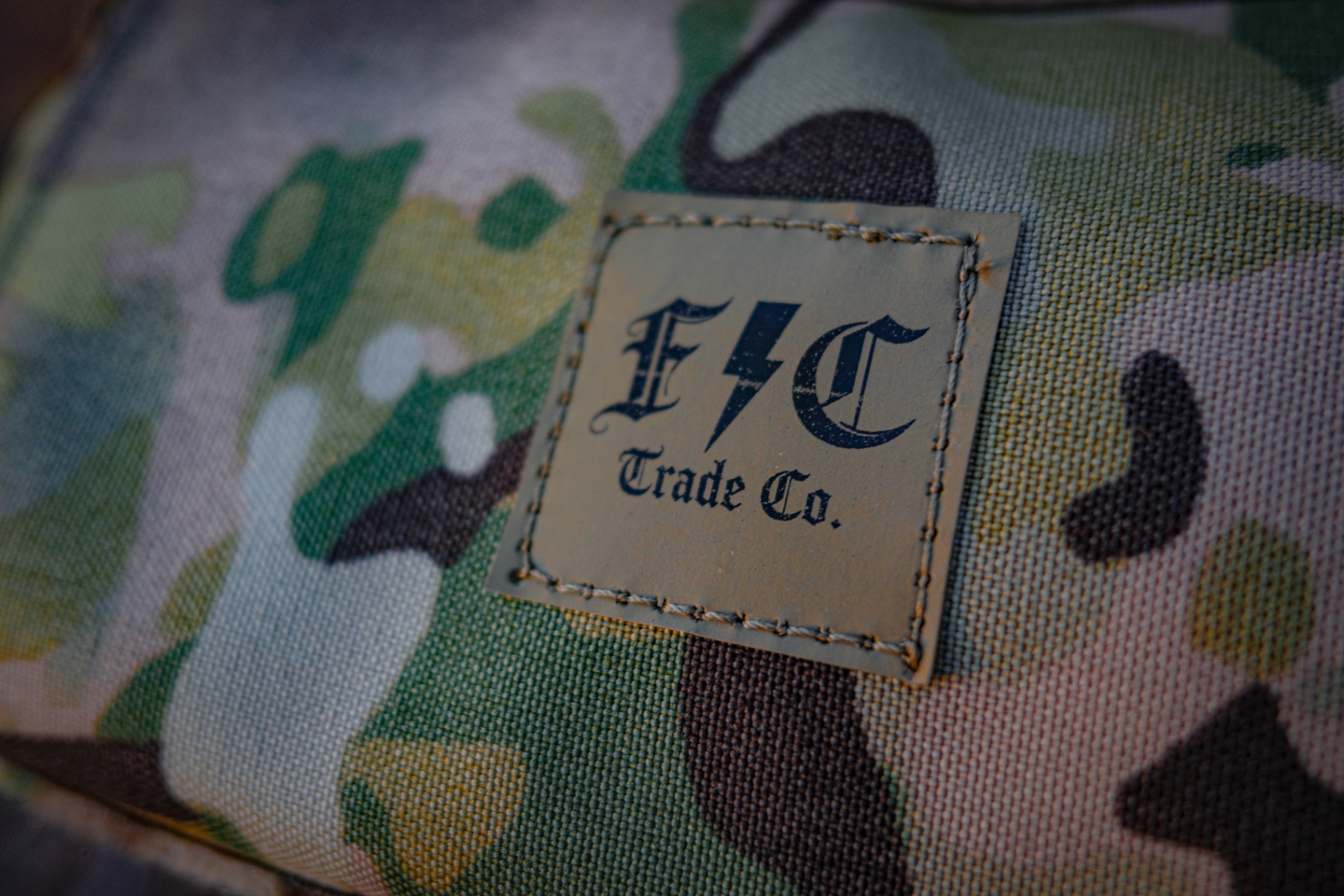 Close-up of the FLC Trade Co. leather patch on MultiCam fabric