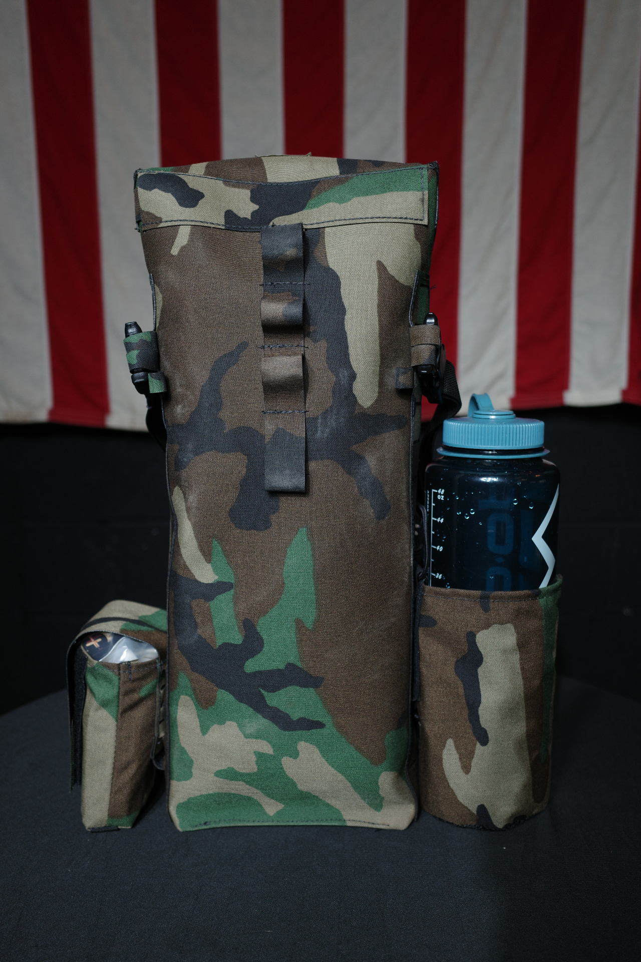 M81 Woodland glove bag with Nalgene bottle in front of an American flag