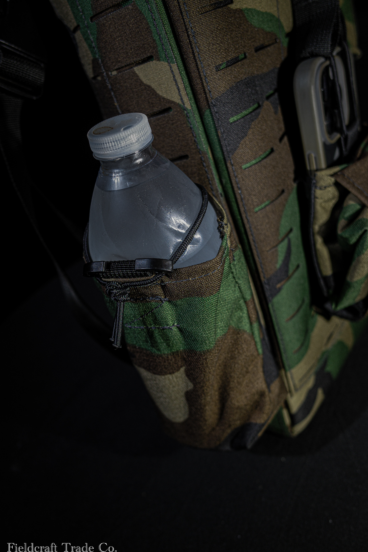 Detail of the M81 Woodland glove bag side pocket holding a water bottle